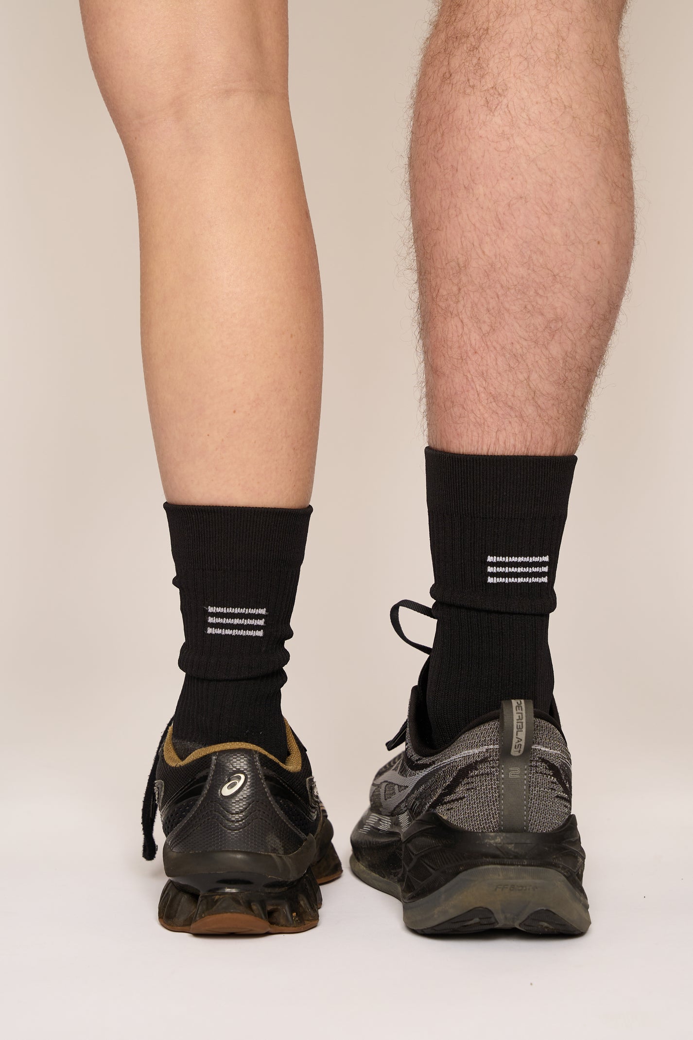 THE DELIVERY SOCKS in black, featuring a ribbed design, worn with athletic shoes.