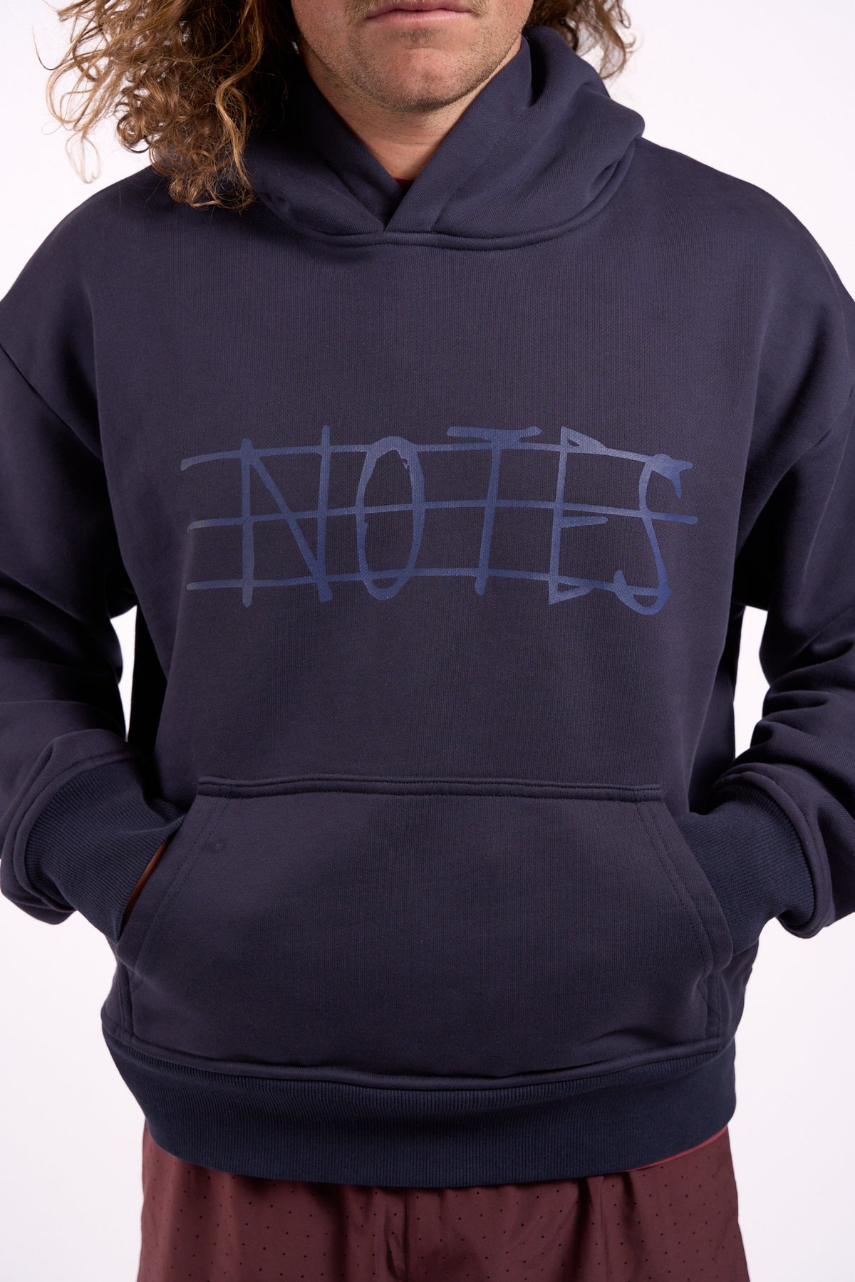 Warm Down Hoodie in Washed Pelagic Blue, front close-up showing Notes graphic and kangaroo pocket