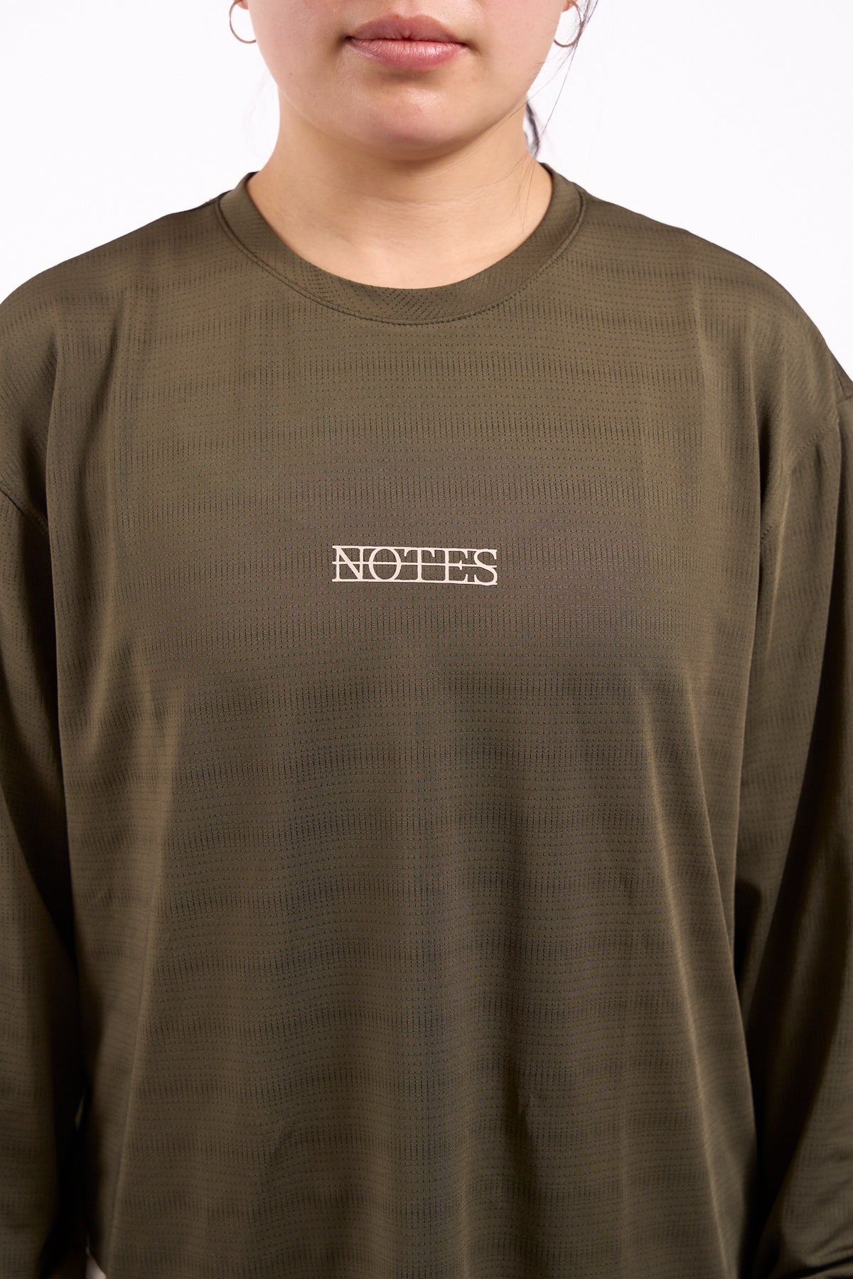 Long Note LS Performance Tee in olive, chest close-up showing Notes logo