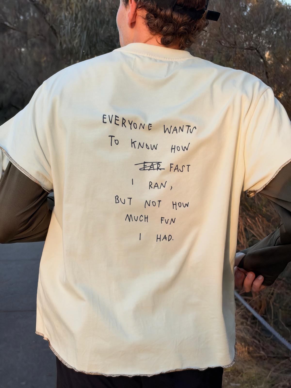 Anniversary Tee in Off White, back view with handwritten print "Everyone wants to know how fast I ran, but not how much fun I had"
