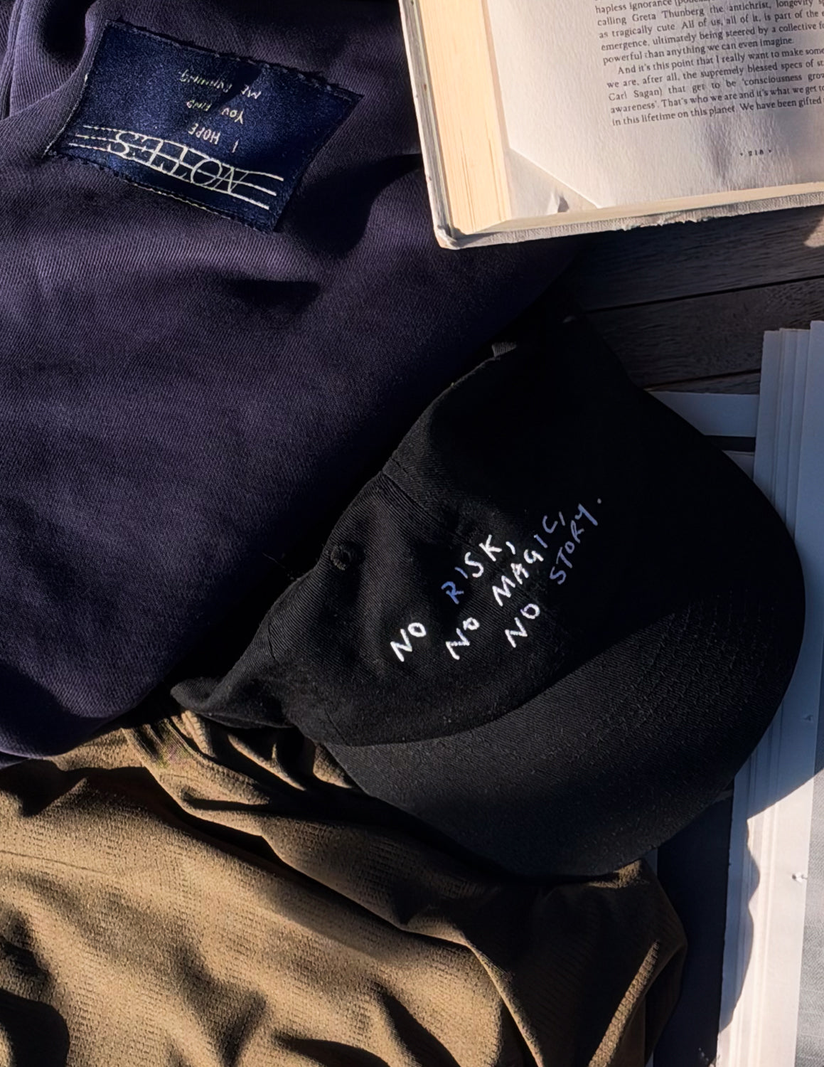 No Risk No Magic No Story Cap in Washed Black, flat lay with front text visible