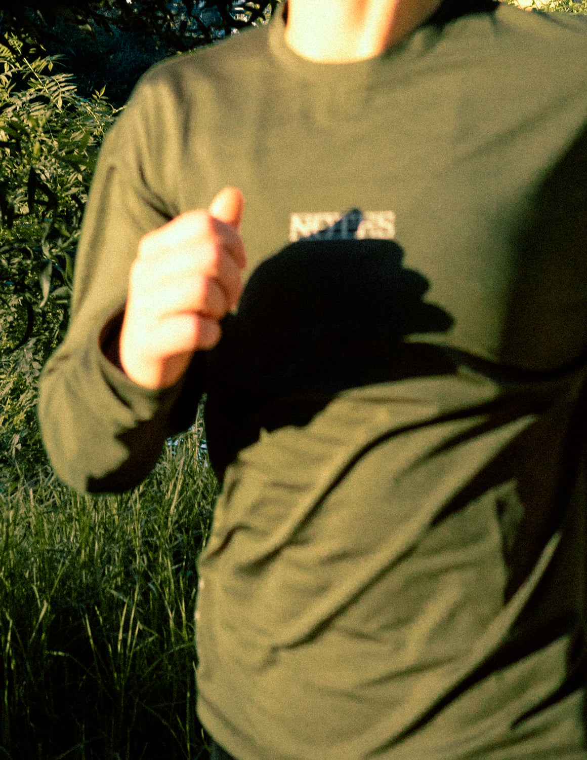 Runner in the Long Note LS Performance Tee in Olive, front view, mid-stride