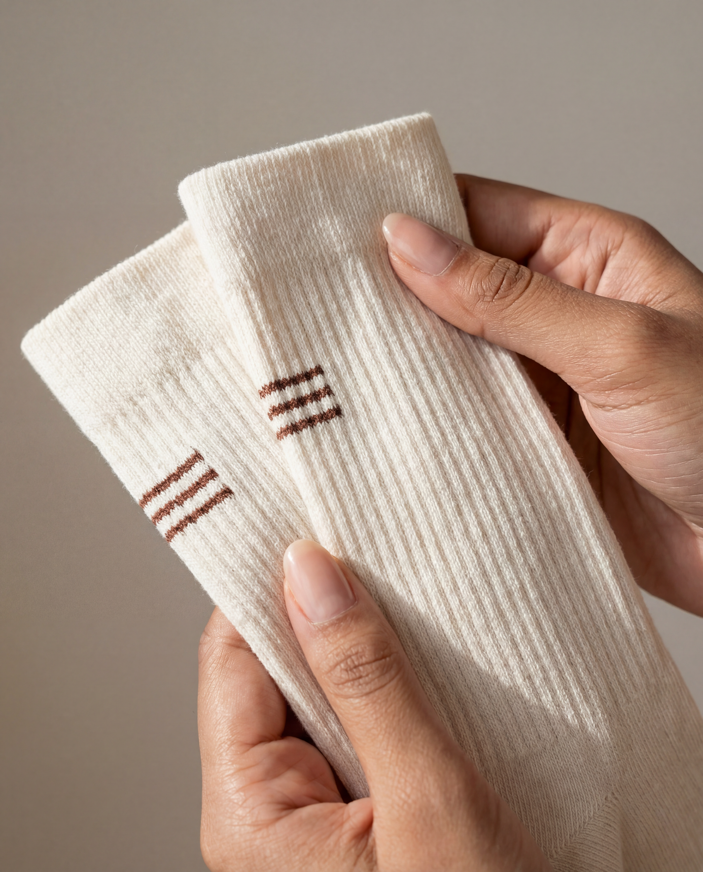 THE DELIVERY SOCKS in off white with ribbed texture and brown stripes.