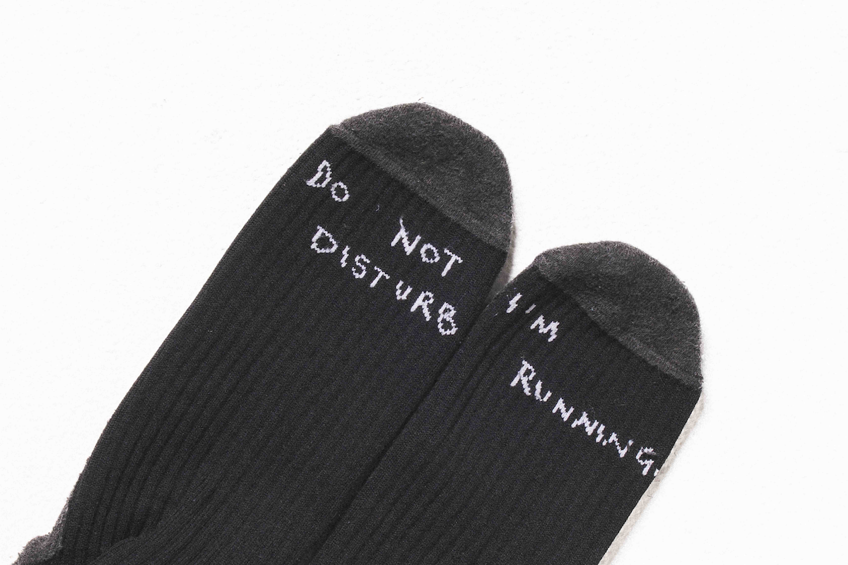 THE DELIVERY SOCKS - BLACK with "Do Not Disturb" and "I'm Running" text on the toes.